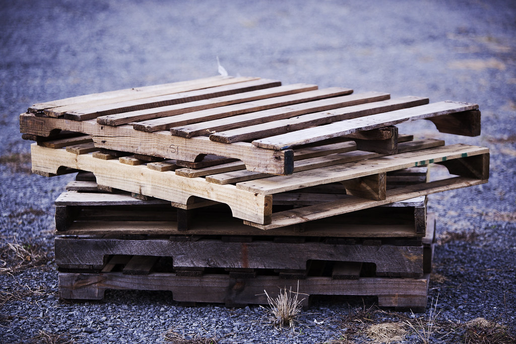 Hàng hoá xếp trên pallet chờ trong kho, tượng trưng cho vốn nằm ở hàng tồn và công nợ